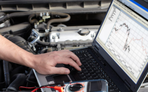 Händer vid laptop i motorutrymme